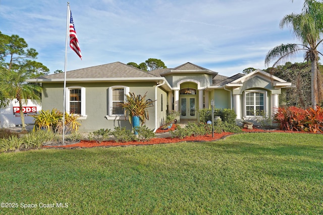 view of front facade with a front yard and french doors