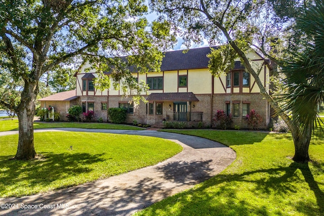 tudor-style house with a front lawn