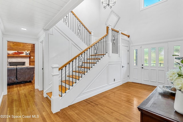 foyer entrance with light hardwood / wood-style floors and crown molding