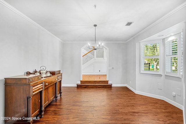 dining space featuring ornamental molding, hardwood / wood-style floors, and a notable chandelier