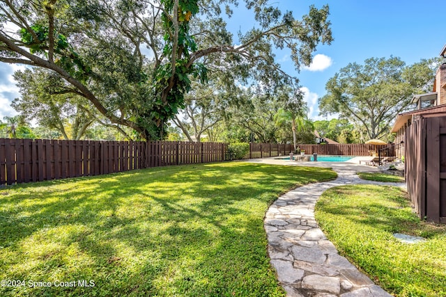 view of yard featuring a patio and a fenced in pool