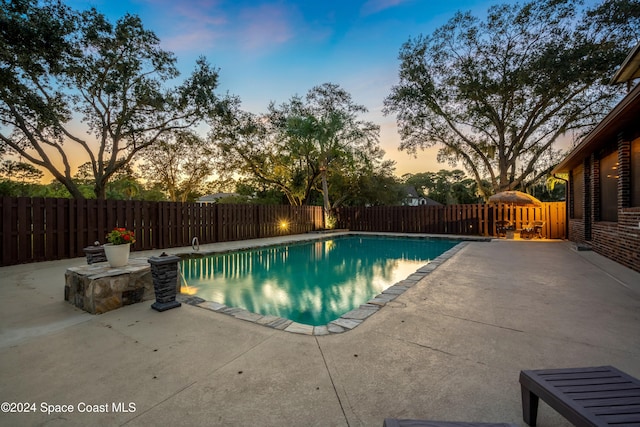 pool at dusk with a patio