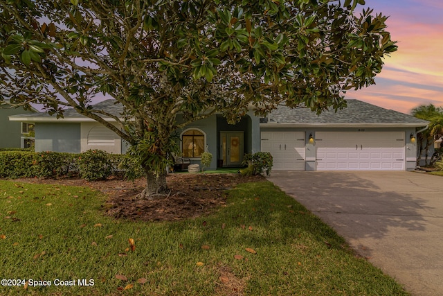 view of front of property featuring a garage and a lawn