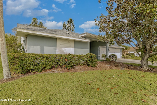 single story home with a garage and a front lawn