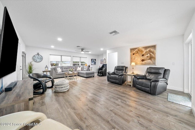 living room with ceiling fan and light hardwood / wood-style floors