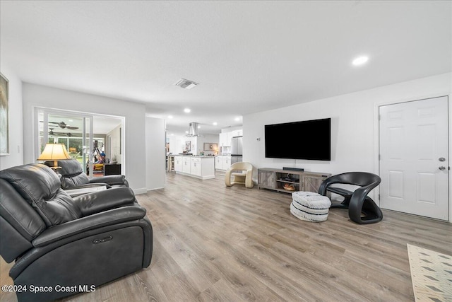 living room featuring light hardwood / wood-style floors and ceiling fan