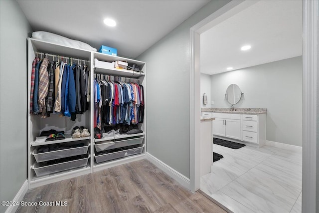 spacious closet featuring sink and light hardwood / wood-style flooring