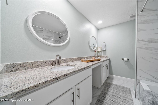 bathroom featuring a textured ceiling and vanity