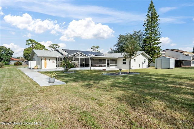 back of property featuring solar panels, a patio, a storage shed, glass enclosure, and a yard