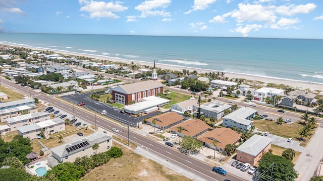 birds eye view of property featuring a water view and a beach view