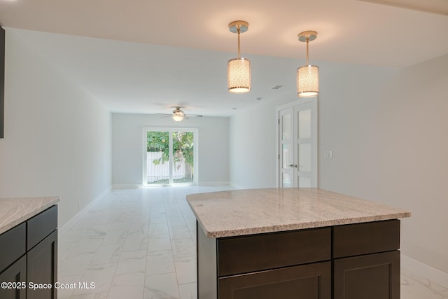 kitchen featuring decorative light fixtures, light stone countertops, ceiling fan, and dark brown cabinetry