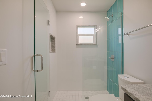 bathroom with a shower with shower door, toilet, and vanity