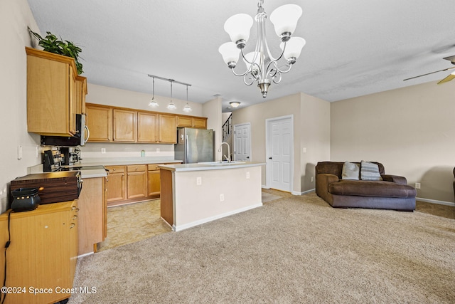 kitchen with light colored carpet, stainless steel fridge, decorative light fixtures, and an island with sink