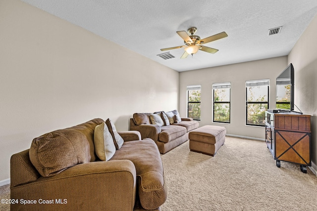 carpeted living room with a textured ceiling and ceiling fan