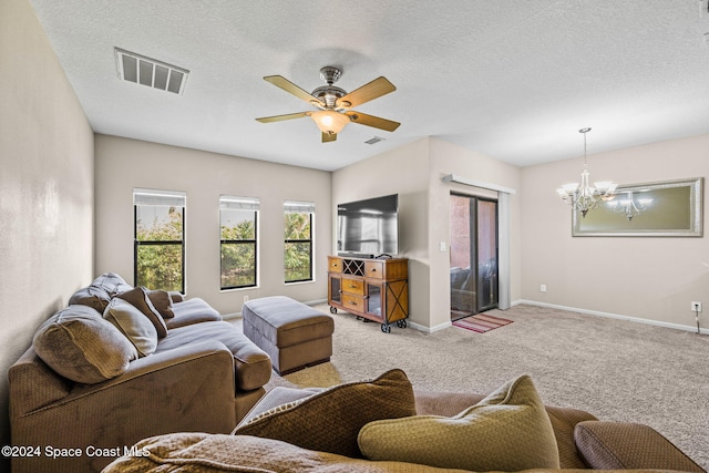 carpeted living room with a textured ceiling and ceiling fan with notable chandelier