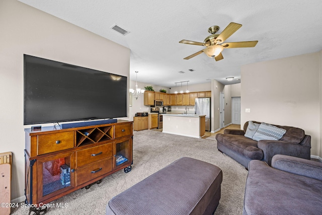 living room with sink, a textured ceiling, light colored carpet, and ceiling fan with notable chandelier