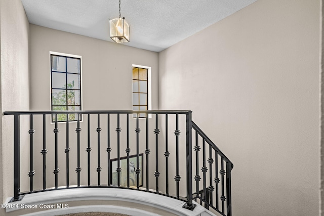 stairs featuring a textured ceiling