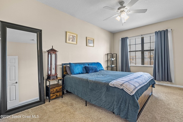 carpeted bedroom featuring a textured ceiling and ceiling fan