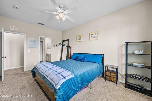 carpeted bedroom with ceiling fan and ensuite bath