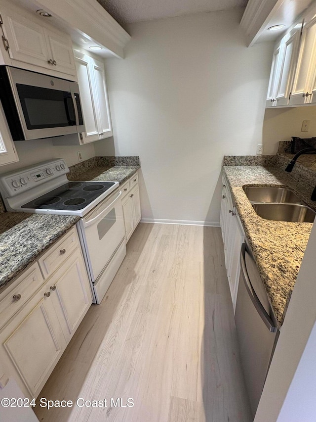 kitchen featuring light hardwood / wood-style floors, appliances with stainless steel finishes, sink, and white cabinets