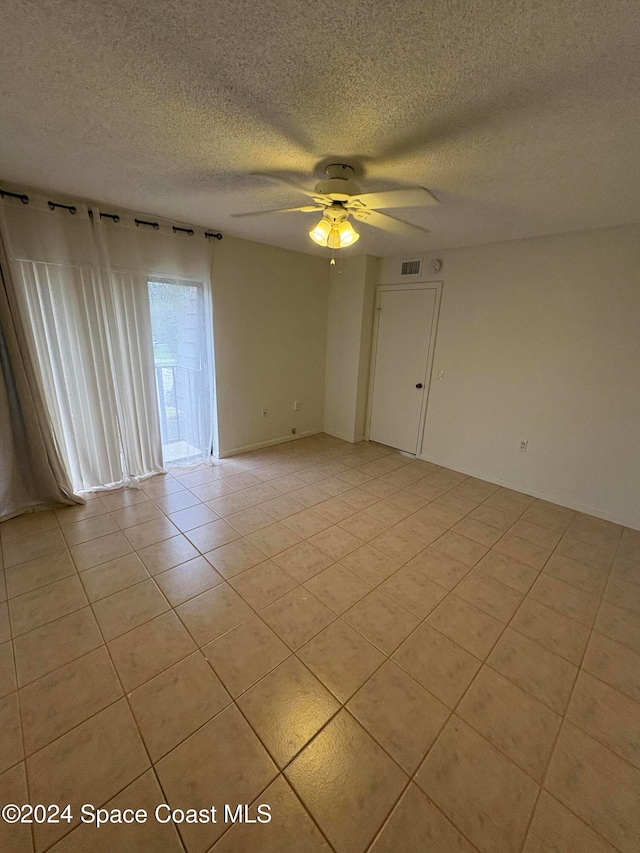 unfurnished room featuring ceiling fan, a textured ceiling, and light tile patterned flooring