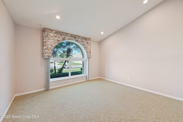 carpeted spare room with lofted ceiling