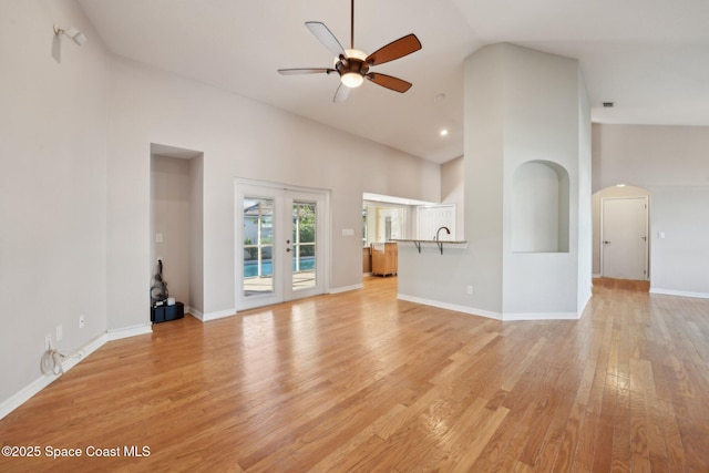 unfurnished living room with ceiling fan, light hardwood / wood-style flooring, and high vaulted ceiling