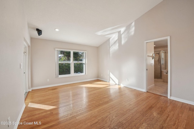 unfurnished bedroom with light hardwood / wood-style flooring and ensuite bath