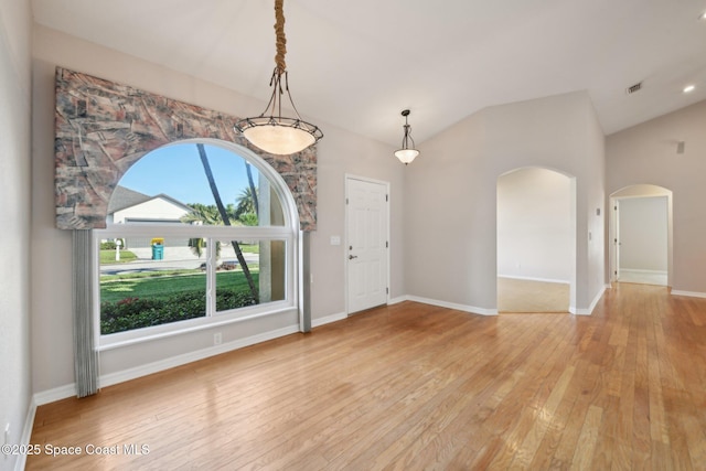 spare room with light hardwood / wood-style flooring and lofted ceiling