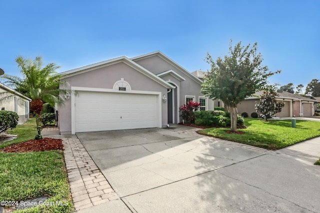 ranch-style home with a front lawn and a garage