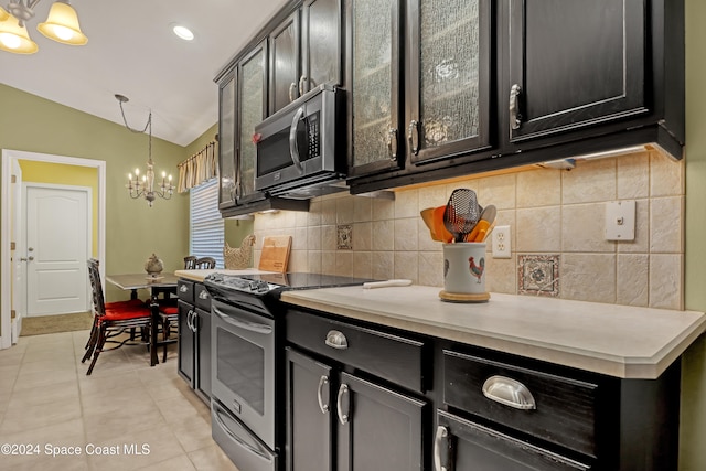 kitchen with stainless steel appliances, light tile patterned floors, decorative light fixtures, a chandelier, and vaulted ceiling