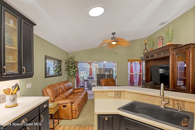 kitchen featuring a healthy amount of sunlight, light hardwood / wood-style flooring, sink, and vaulted ceiling