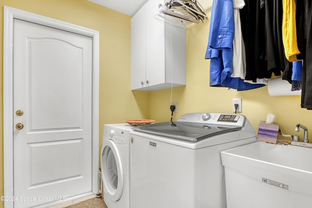 laundry room featuring cabinets, washing machine and dryer, and sink