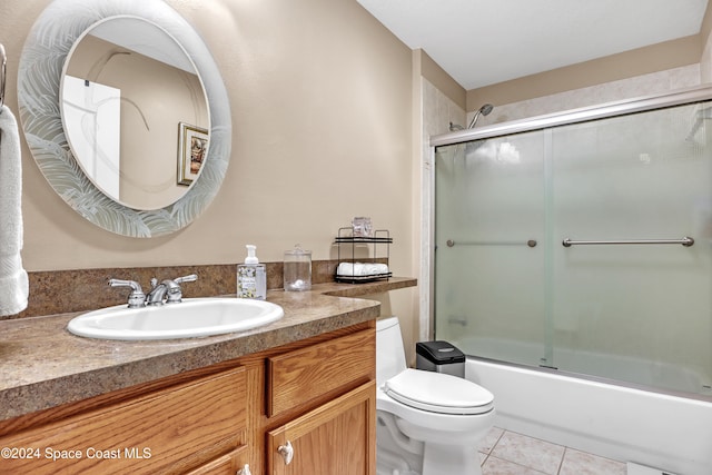 full bathroom with tile patterned flooring, vanity, combined bath / shower with glass door, and toilet