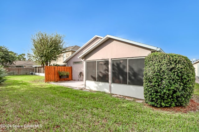 back of property featuring a patio, a sunroom, and a yard