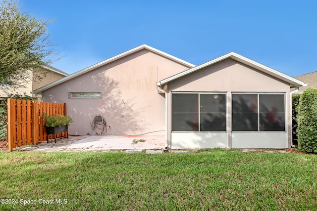 back of property featuring a patio, a sunroom, and a yard