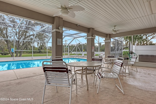 view of swimming pool featuring a lanai, ceiling fan, and a patio