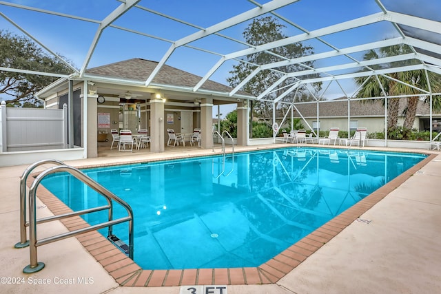 view of swimming pool featuring a lanai, ceiling fan, and a patio area