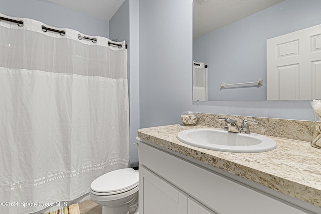 bathroom featuring a shower with curtain, vanity, a textured ceiling, and toilet