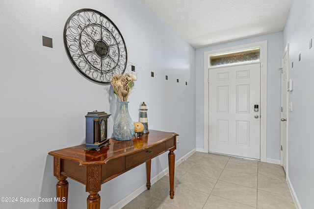 tiled foyer with a textured ceiling