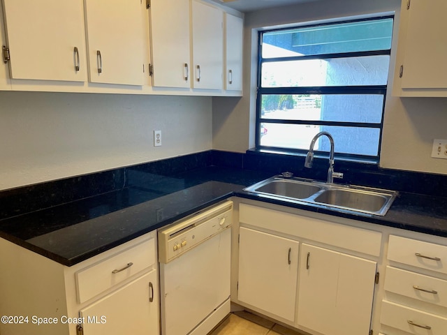 kitchen with dishwasher, sink, light tile patterned floors, and white cabinets