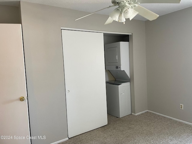 laundry room with ceiling fan, stacked washer and dryer, and carpet floors