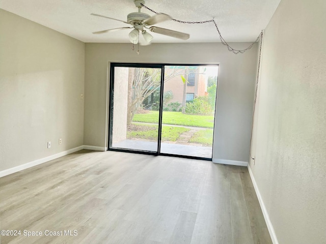 empty room with light wood-type flooring, a textured ceiling, and ceiling fan