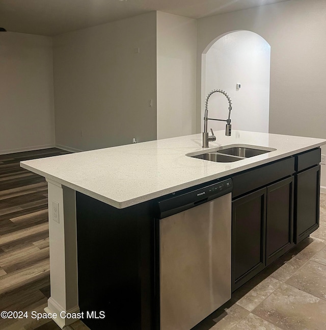 kitchen with a center island with sink, light stone countertops, light hardwood / wood-style flooring, dishwasher, and sink