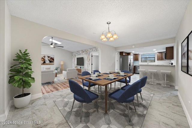 dining room featuring lofted ceiling, a textured ceiling, and ceiling fan with notable chandelier