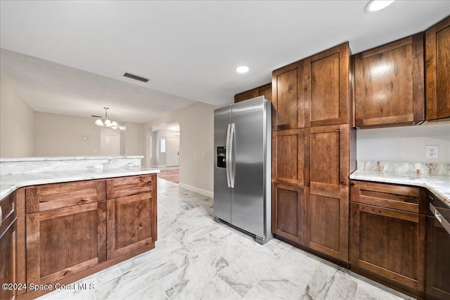 kitchen featuring stainless steel refrigerator with ice dispenser and a chandelier