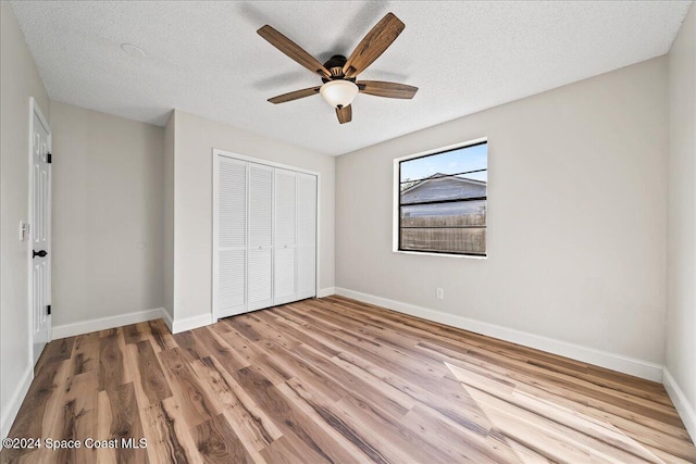 unfurnished bedroom with a closet, ceiling fan, a textured ceiling, and light hardwood / wood-style floors