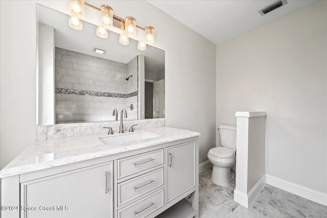 bathroom featuring vanity, toilet, and a tile shower