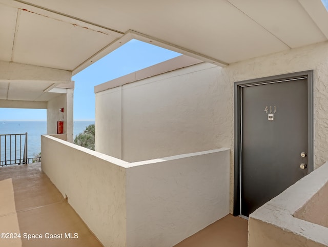 doorway to property featuring a balcony and a water view