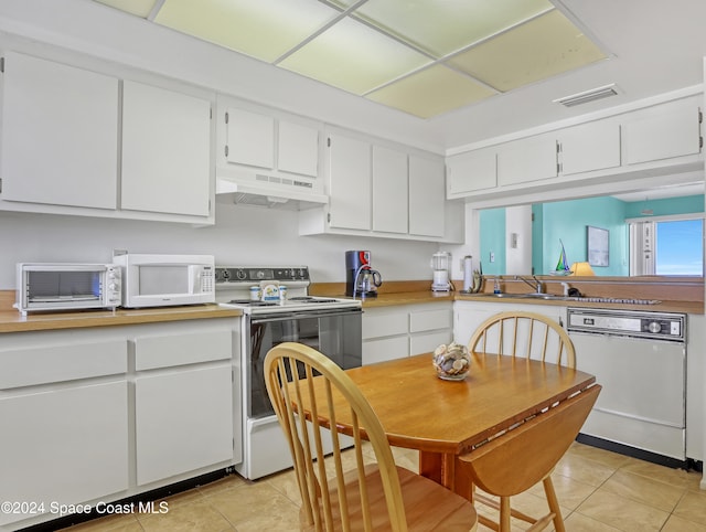 kitchen featuring sink, white cabinetry, white appliances, and light tile patterned flooring